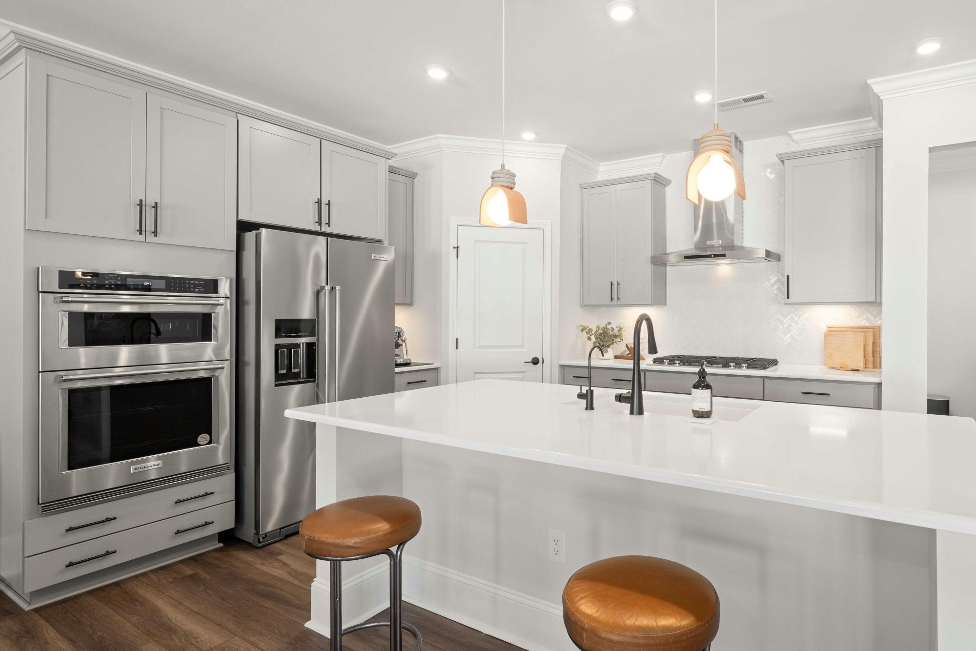 Modern kitchen with quartz countertops, stainless steel appliances, and pendant lighting by Managed Renovations in Chevy Chase, MD stock-optimized