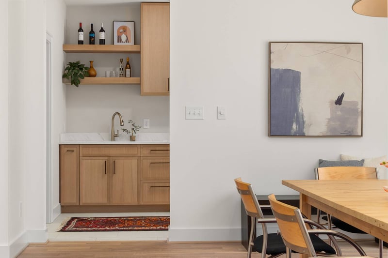 Modern wet bar with open shelving and quartz countertop beside the dining area in a Chevy Chase, MD home addition by Managed Ren-optimized