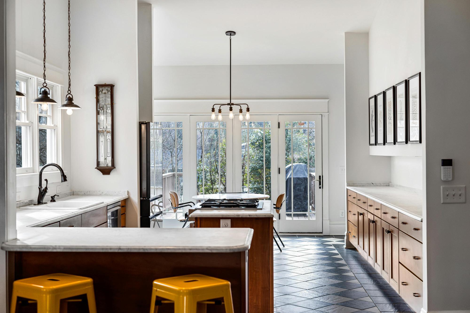 Open-concept kitchen with wood cabinetry, large island, and natural light by Managed Renovations in Chevy Chase, MD stock-optimized