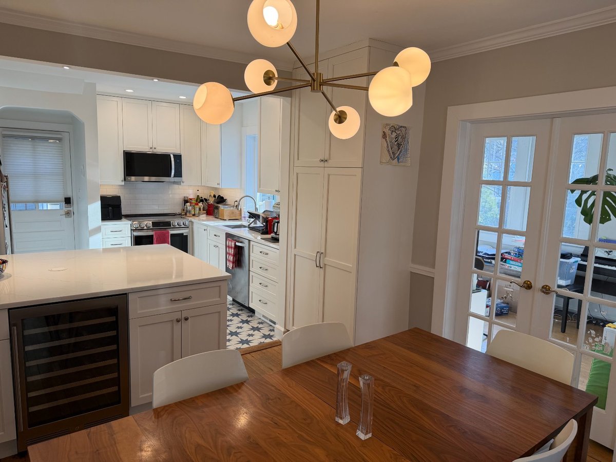 Bright white kitchen remodel in Chevy Chase, MD with a large quartz island and custom cabinetry.