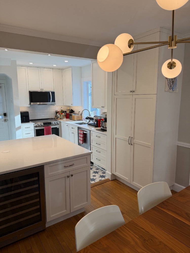 Kitchen remodel in Chevy Chase, MD featuring a quartz island, custom cabinetry, and modern pendant lighting.