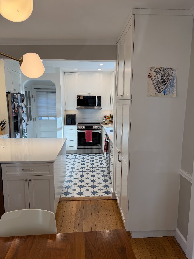 Kitchen remodel in Chevy Chase, MD highlighting full-height pantry cabinetry and a modern white kitchen.