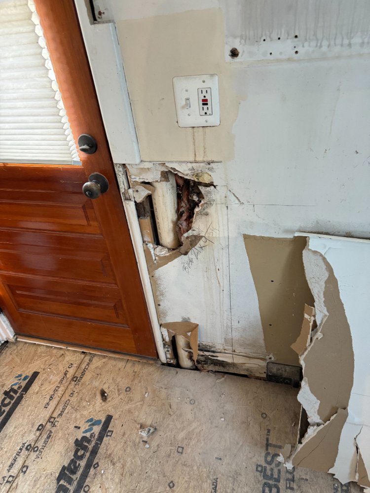 Wall demolition around the exterior door during the kitchen remodel in Chevy Chase, MD, exposing framing.