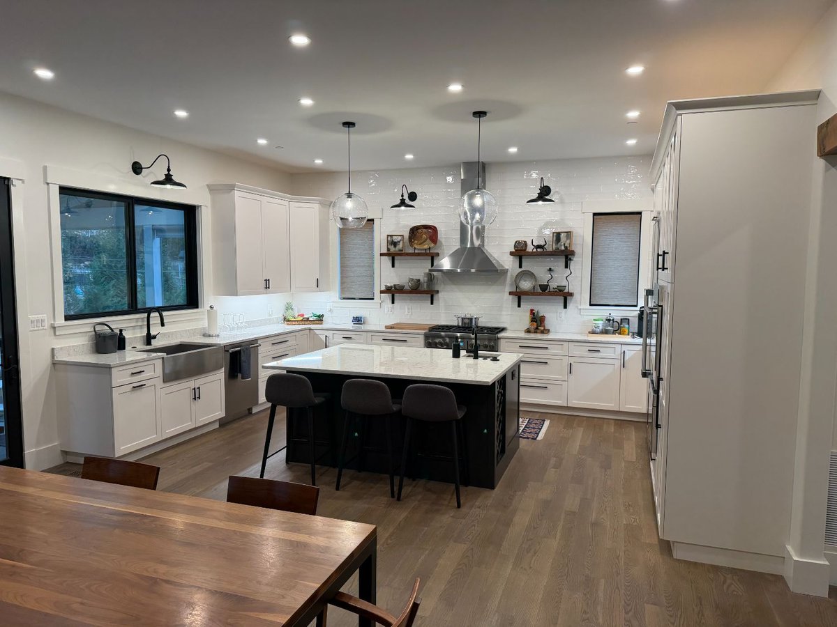 Angled view of the new house custom kitchen in Chevy Chase, MD featuring a large island and built-in appliances.
