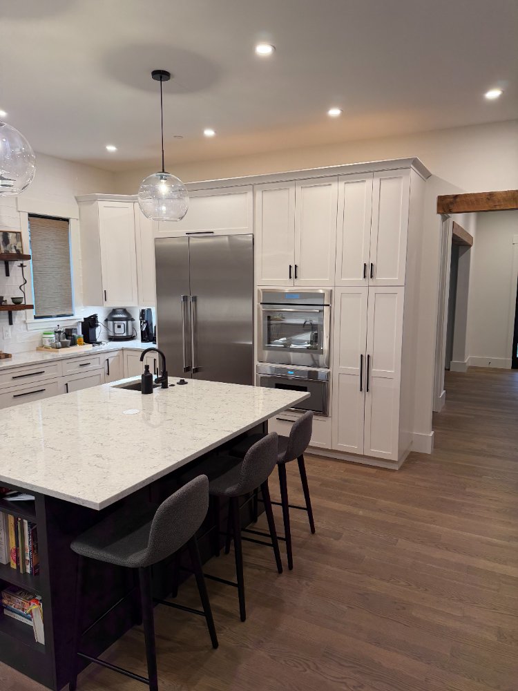 View of the new house custom kitchen in Chevy Chase, MD featuring a large island and floating shelves.