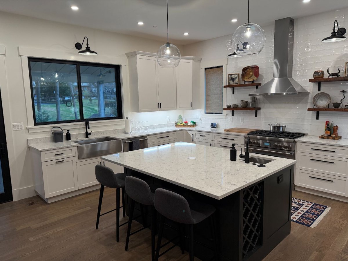 Wide-angle view of the new house custom kitchen in Chevy Chase, MD featuring a large island and white cabinetry.