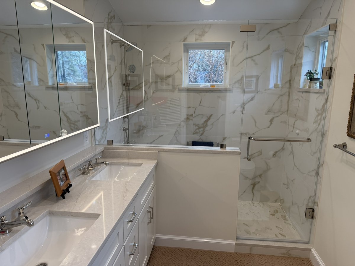 primary suite addition bathroom with double vanity illuminated mirrors and glass shower in chevy chase md
