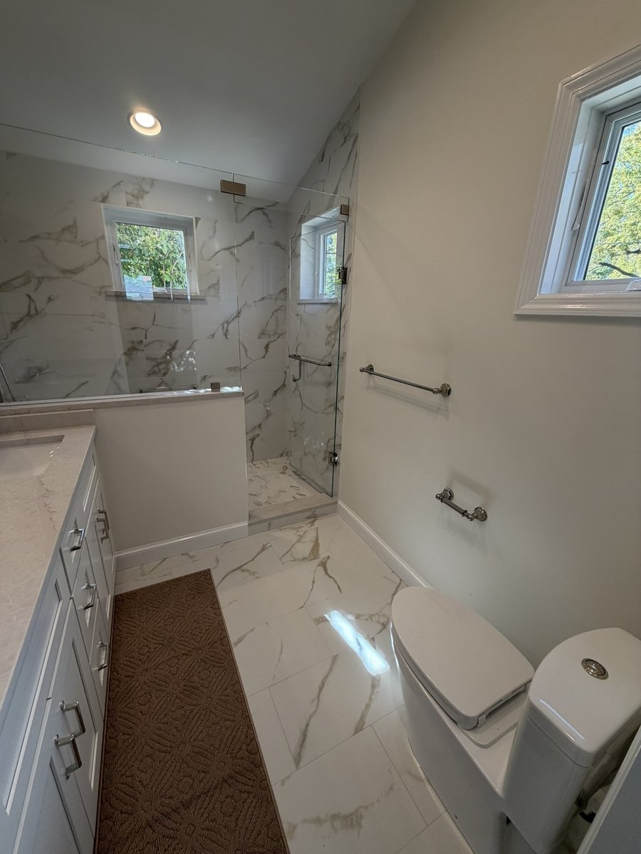 primary suite addition bathroom with marble tile floor glass shower and modern toilet in chevy chase md