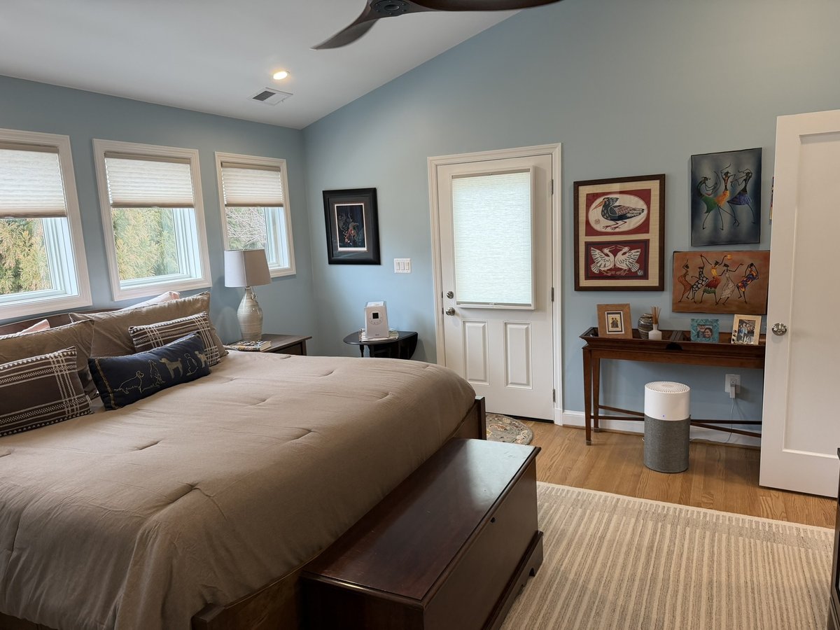 primary suite addition bedroom with blue walls hardwood floors and exterior door in chevy chase md