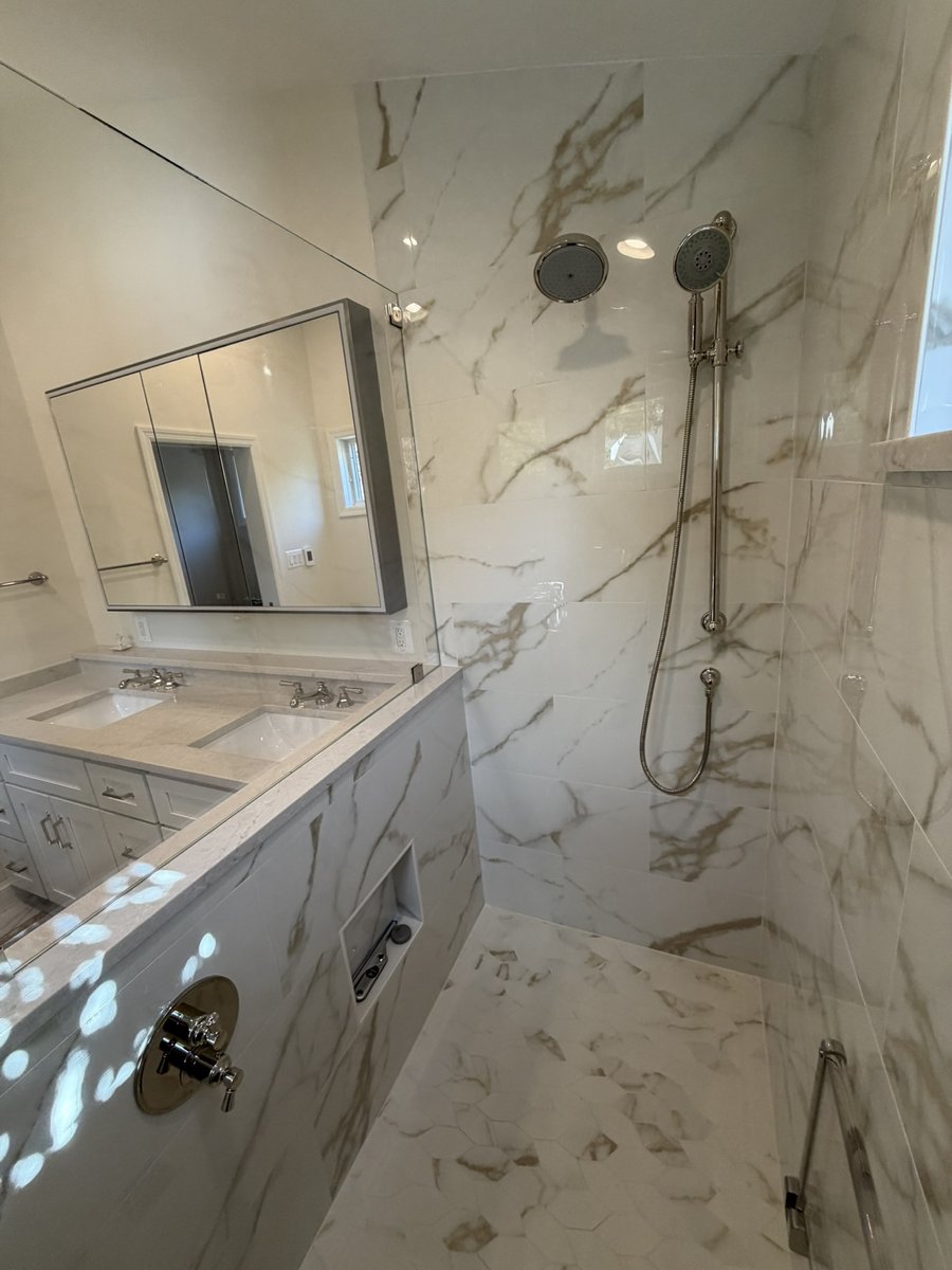 primary suite addition marble tile shower with rainfall and handheld fixtures in chevy chase md
