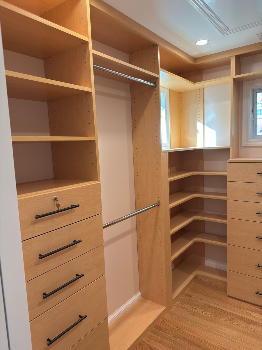 primary suite addition walk in closet with custom wood shelving drawers and hanging rods in chevy chase md