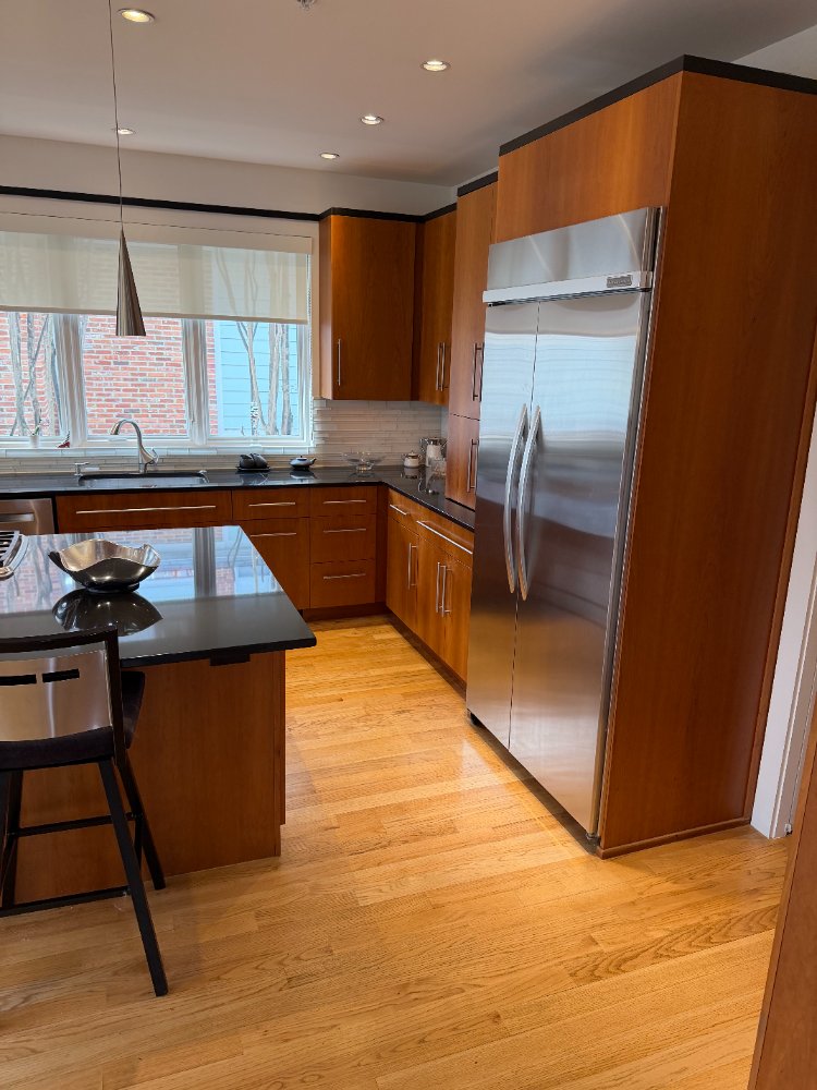 Custom new house kitchen in Chevy Chase, MD featuring stainless steel appliances and warm wood cabinetry.