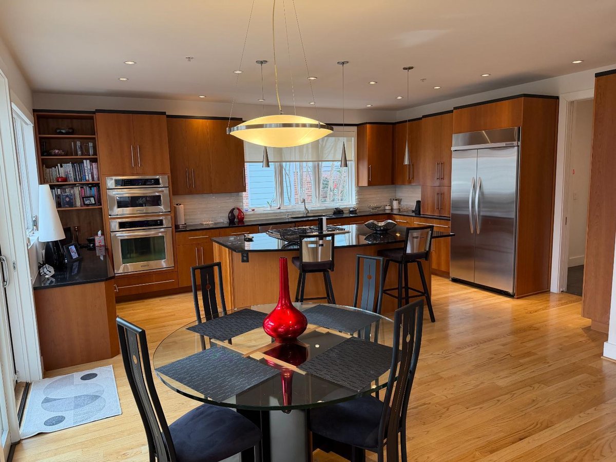 Open-concept custom kitchen and dining area in Chevy Chase, MD featuring hardwood floors and modern cabinetry.