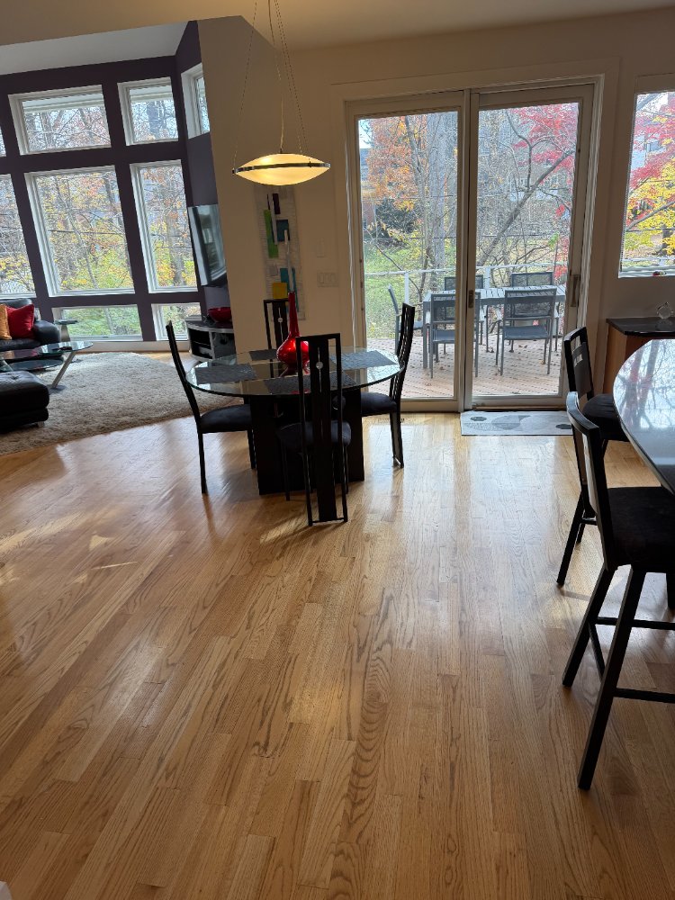 Open-concept kitchen and dining area in a new house in Chevy Chase, MD with large windows.