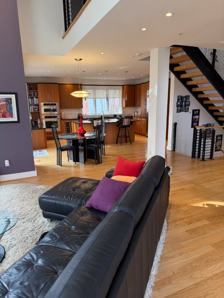 Open-concept living room and custom kitchen in Chevy Chase, MD with hardwood flooring and modern design.