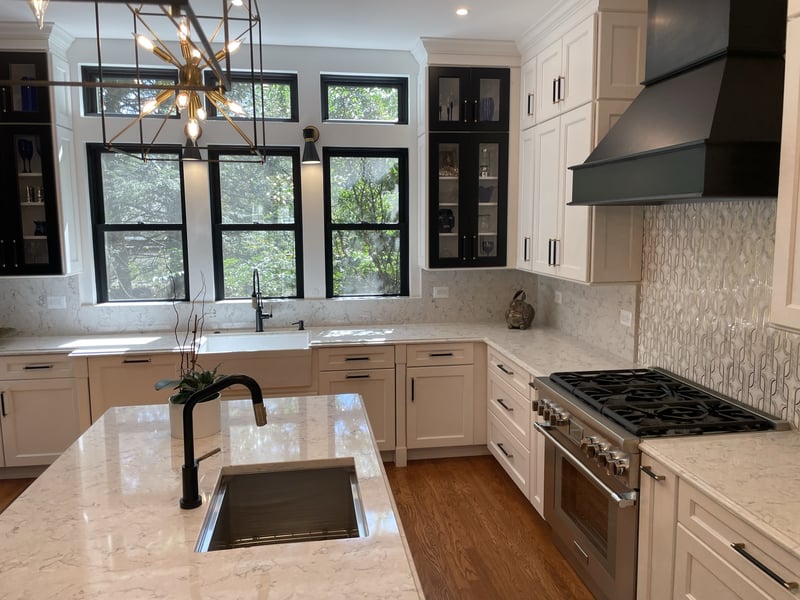 kitchen island with prep sink facing stainless range and black range hood in chevy chase md kitchen and hall bath remodel