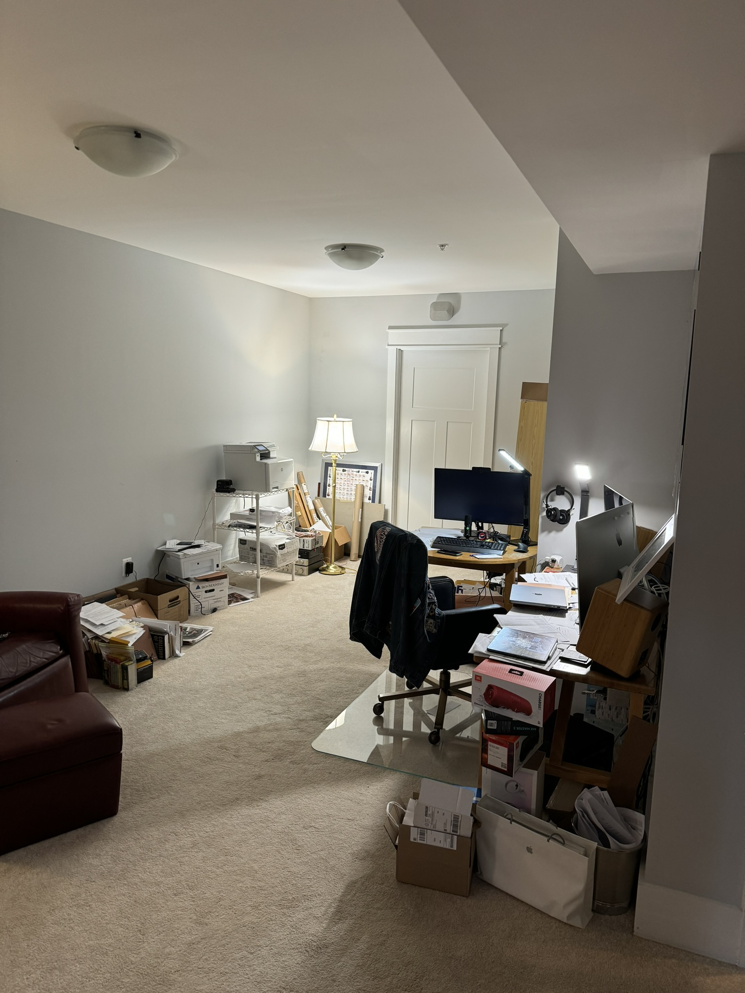 before office remodel in Cabin John, MD showing carpeted workspace with desks computers storage boxes and gray walls