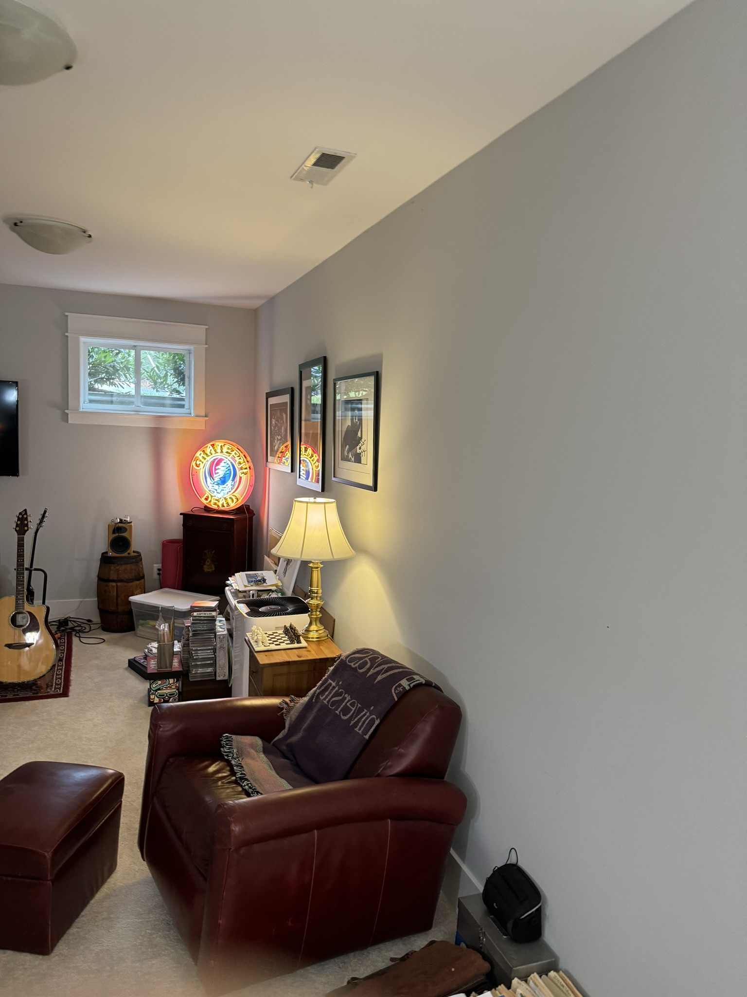 before office remodel in Cabin John, MD showing leather chair guitar music decor carpet flooring and an unfinished gray wall