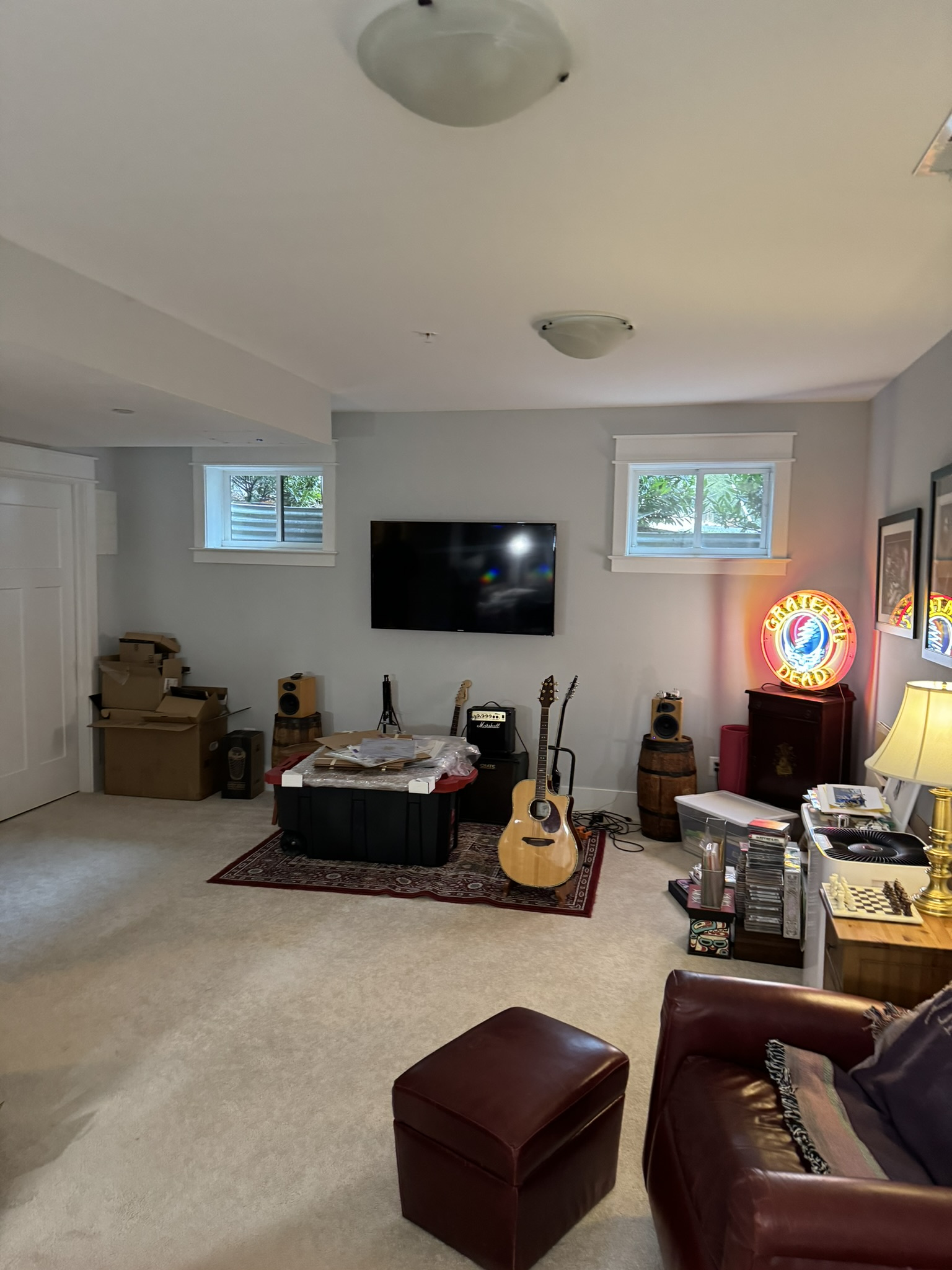 before office remodel in Cabin John, MD showing wall mounted television guitars speakers carpet flooring and music themed decor