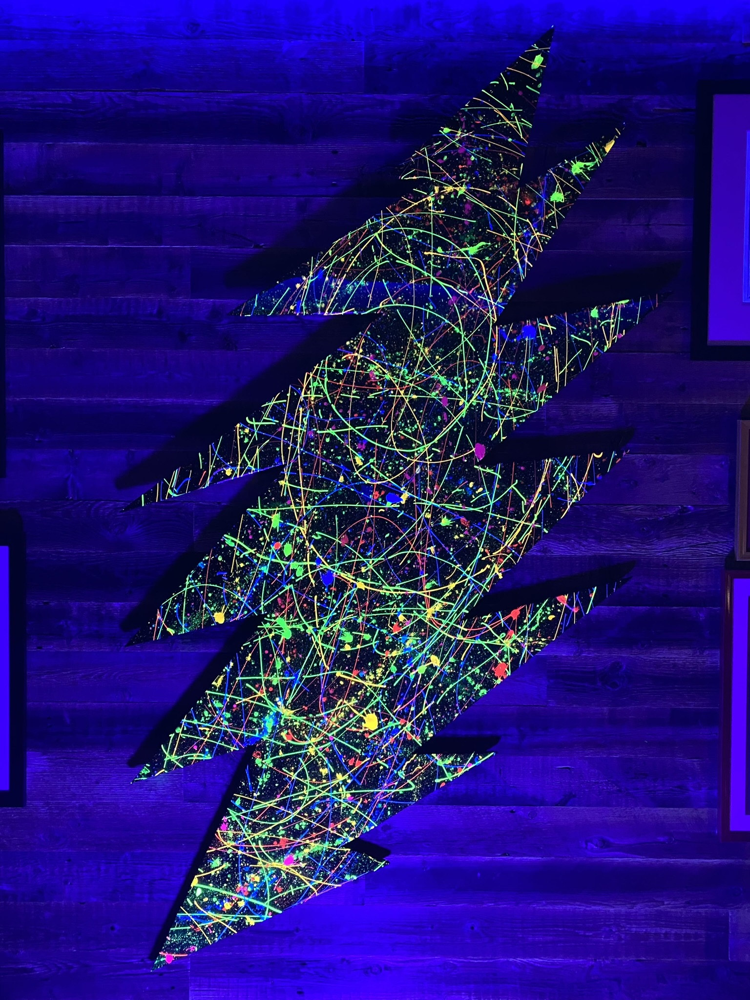 office remodel detail in Cabin John, MD featuring colorful abstract lightning bolt wall art illuminated by blue accent lighting