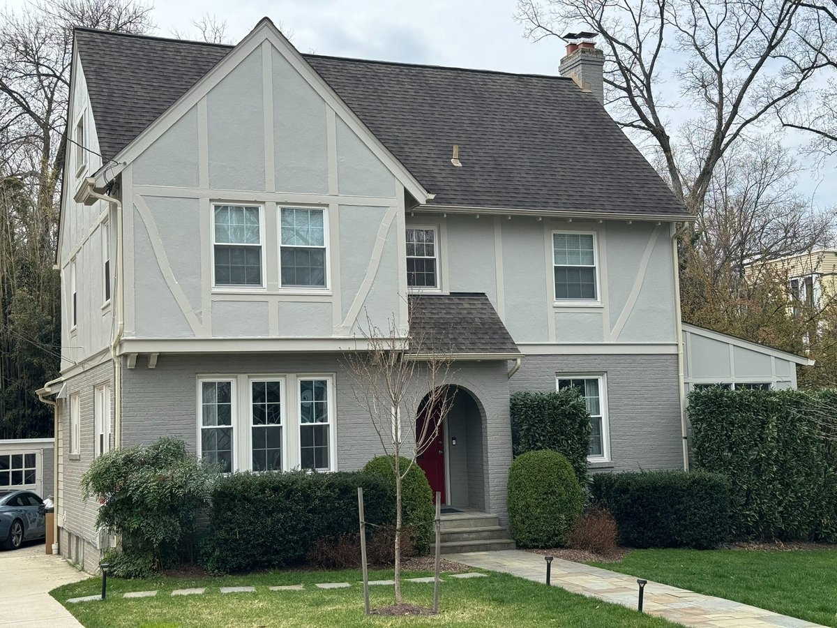front exterior of a gray tudor home with a side addition in chevy chase md