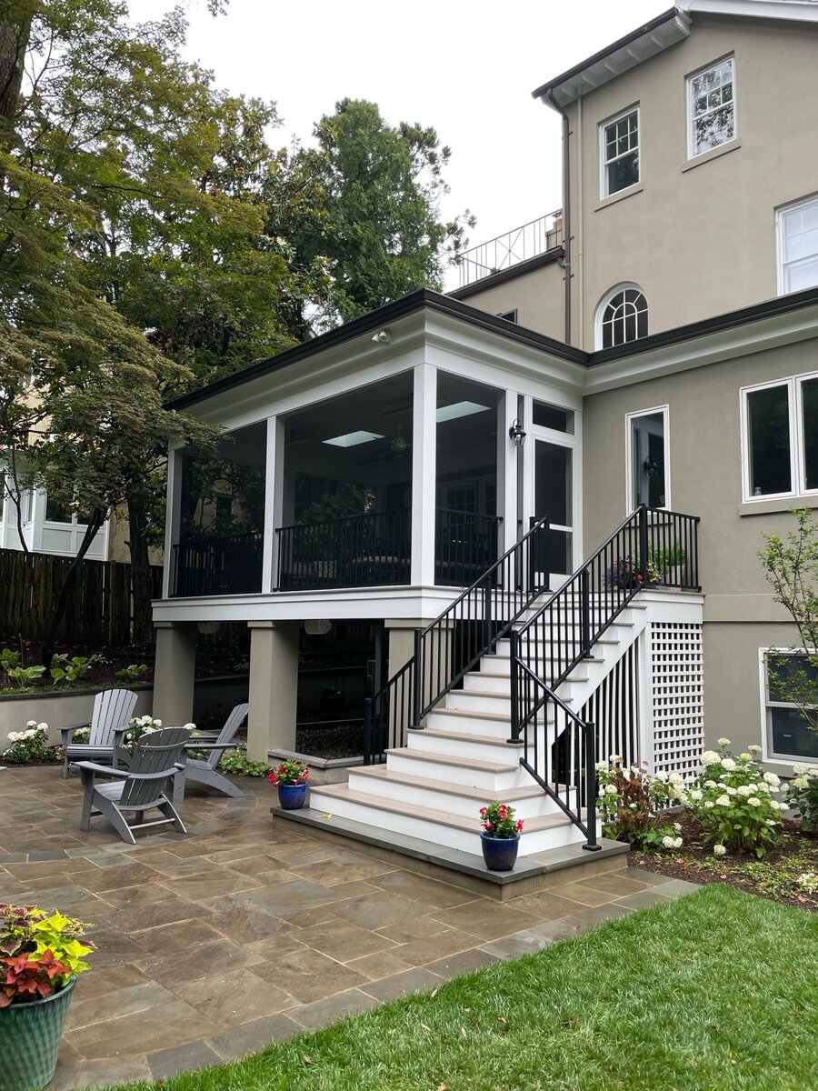 addition and exterior hardscaping with screened porch black railings white stairs and stone patio in chevy chase md