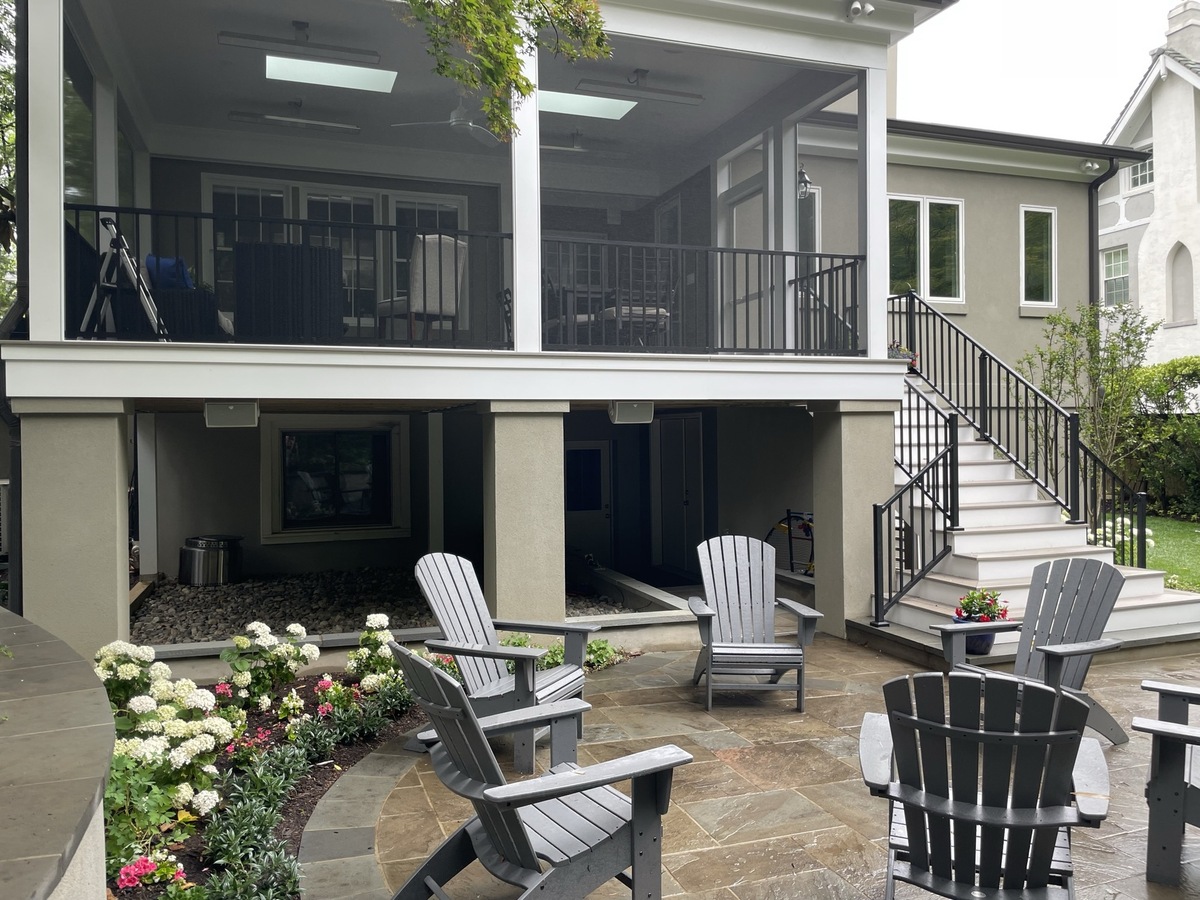 addition and exterior hardscaping with screened porch staircase stone patio and adirondack chairs in chevy chase md