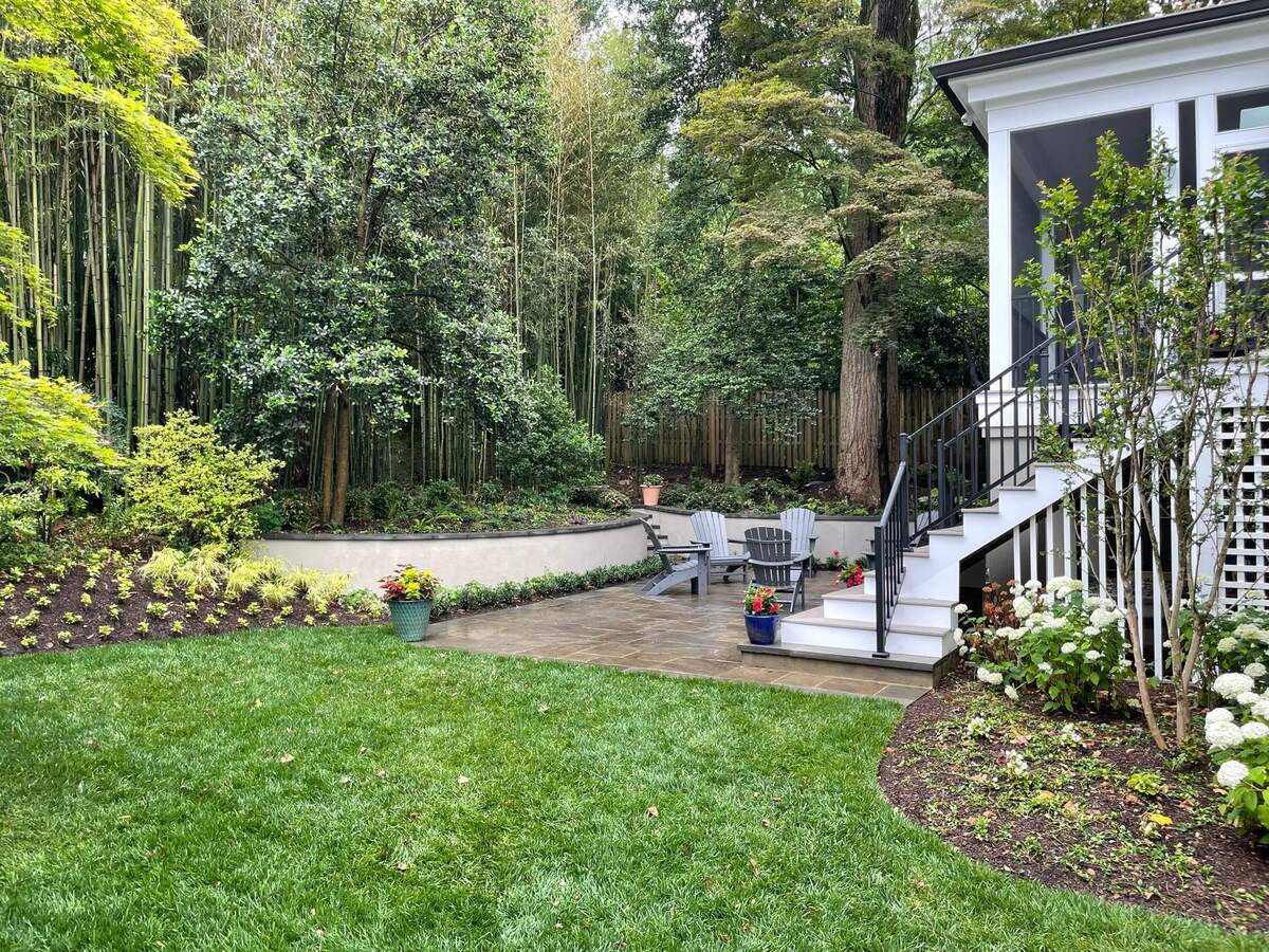 addition and exterior hardscaping with stone patio adirondack seating and screened porch in chevy chase md