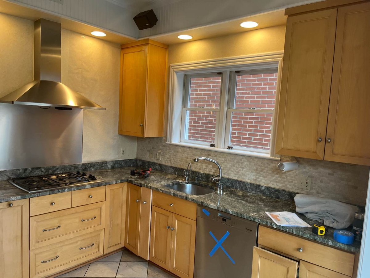 Existing kitchen sink, cooktop, and cabinetry before remodeling in Northwest Washington, D.C.