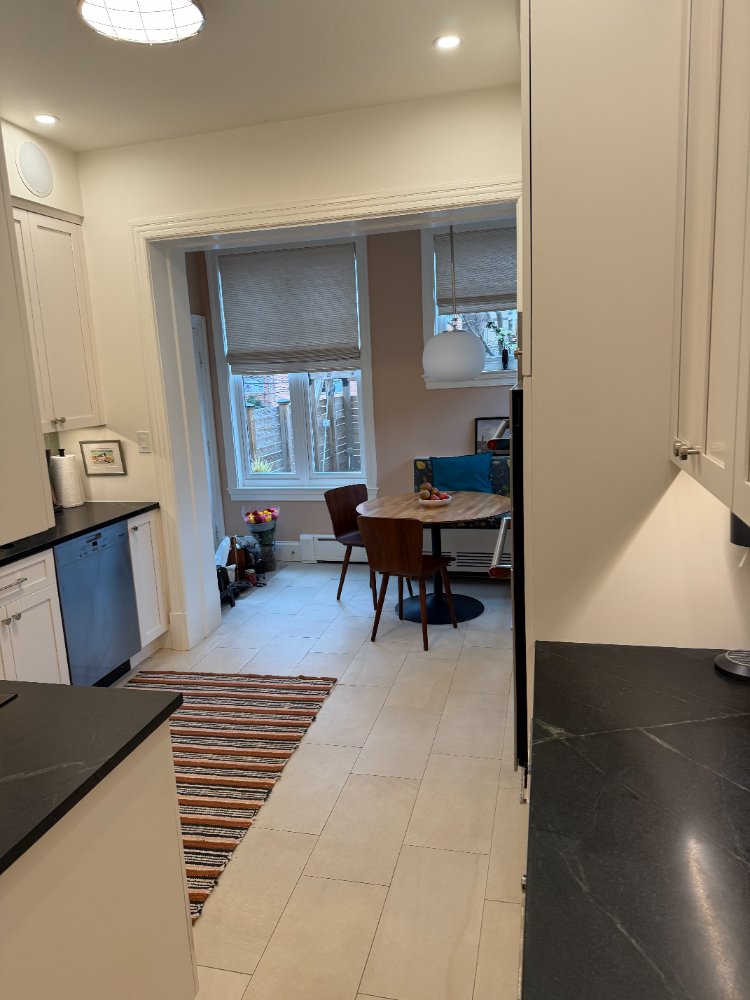 Kitchen remodel featuring black countertops, custom cabinetry, and an adjoining breakfast area in Northwest Washington, D.C.