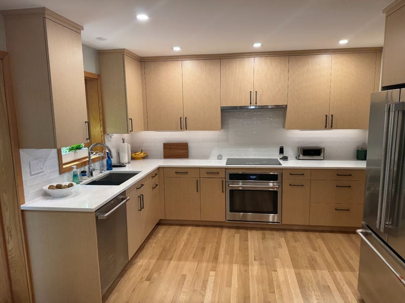 After view of the remodeled kitchen with custom cabinetry, quartz countertops, and integrated appliances by Managed Renovations -optimized