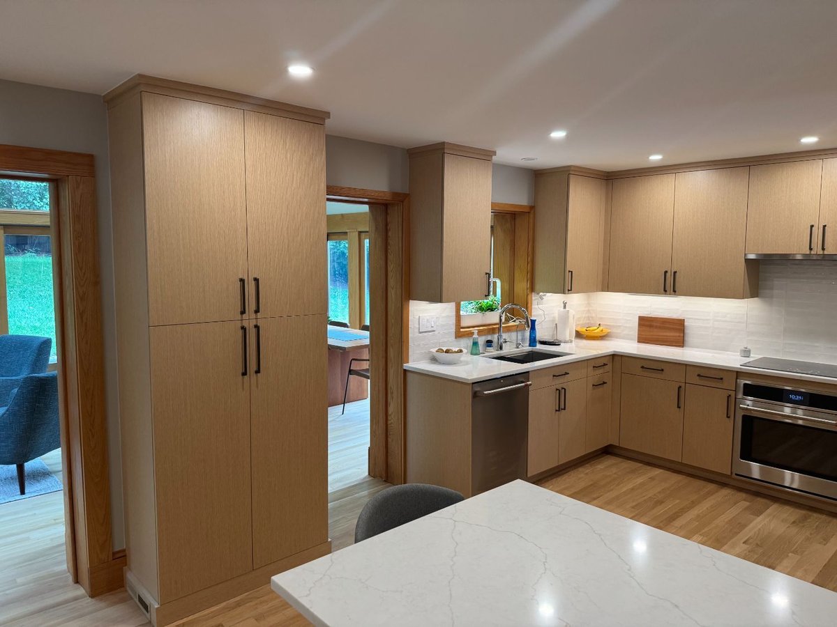 Finished kitchen renovation showcasing tall pantry cabinets and quartz island in Kensington, MD.