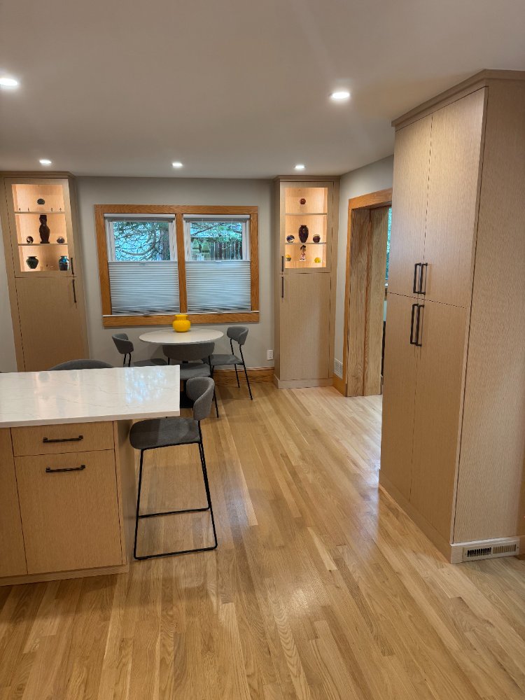 Kitchen dining area featuring custom cabinetry and illuminated display cabinets.