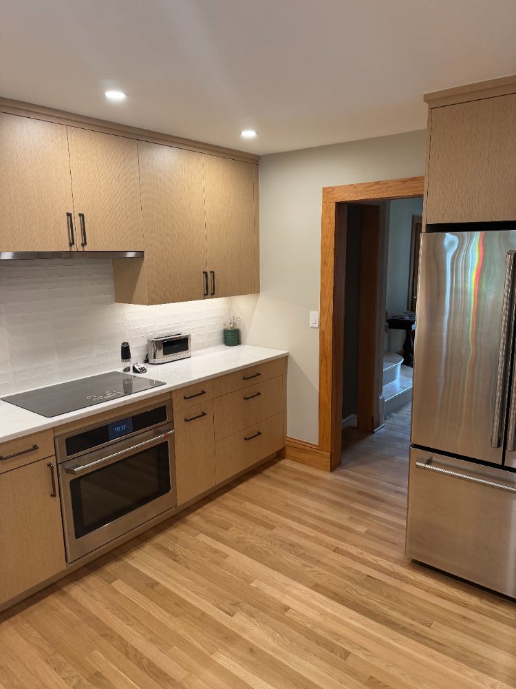Sleek cooking area featuring custom cabinetry and white quartz countertops.