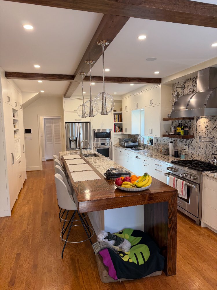 Bright custom kitchen remodel in Northwest Washington, D.C. featuring a waterfall island and wood breakfast bar.