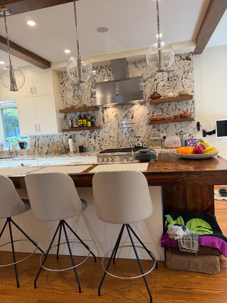Modern Northwest Washington, D.C. kitchen renovation showcasing premium stone countertops and floating shelves.
