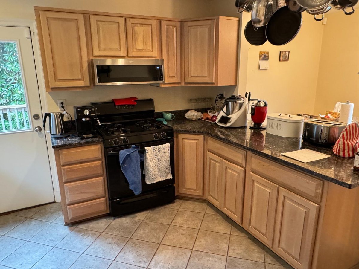 Existing kitchen with wood cabinetry and black countertops before remodeling in Chevy Chase, MD.