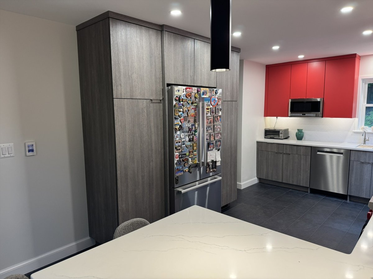 Kitchen remodel featuring a tall gray pantry cabinet, stainless steel refrigerator, and red accent cabinetry in Chevy Chase, MD