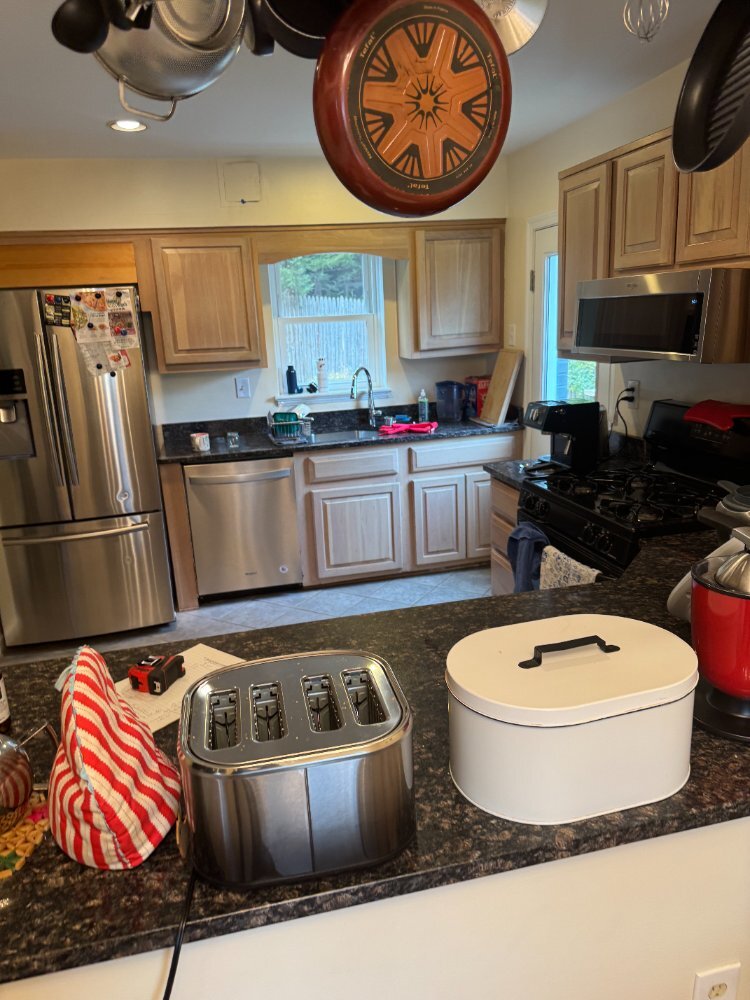 Original kitchen layout featuring stainless steel appliances before renovation in Chevy Chase, MD.