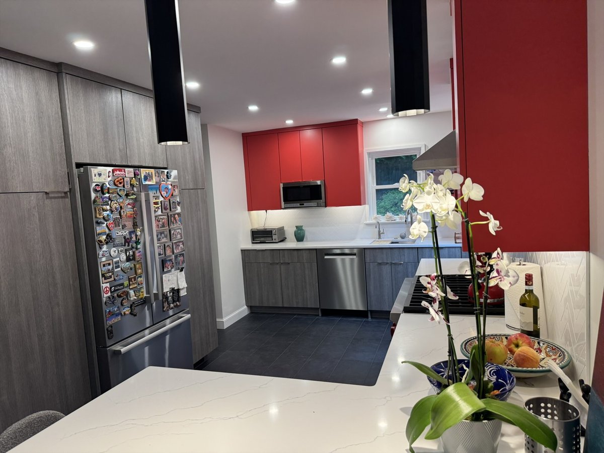 Remodeled kitchen with a stainless steel refrigerator, red upper cabinets, and a stainless microwave in Chevy Chase, MD - optimi