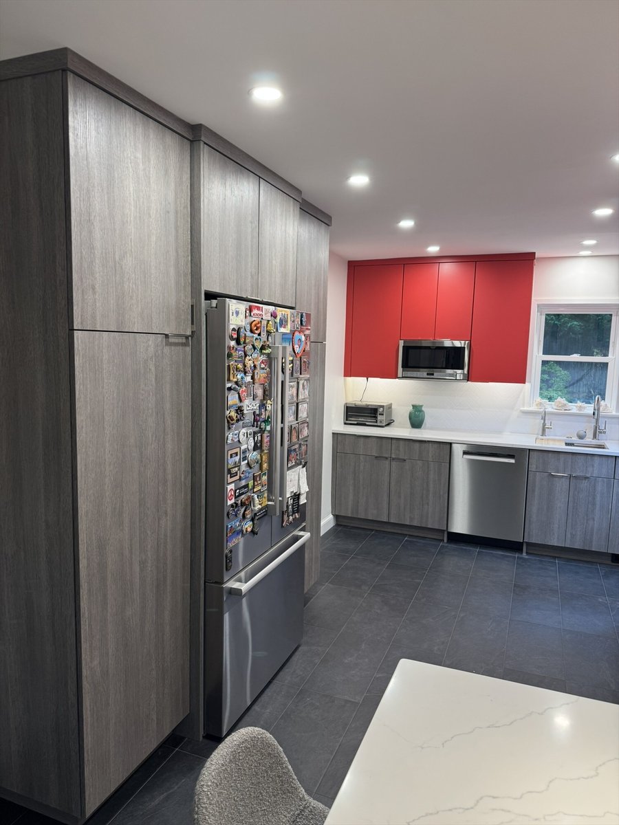 Remodeled kitchen with gray flat-panel cabinets, red accent uppers, and a stainless steel refrigerator in Chevy Chase, MD - opti