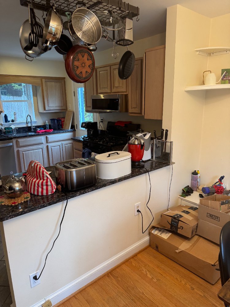 View of the original kitchen peninsula and storage before renovation in Chevy Chase, MD.