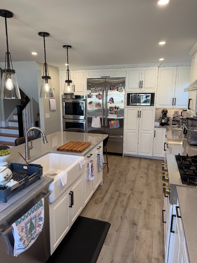 Kitchen remodel in Bethesda, MD featuring a farmhouse sink, quartz island, and white shaker cabinets.