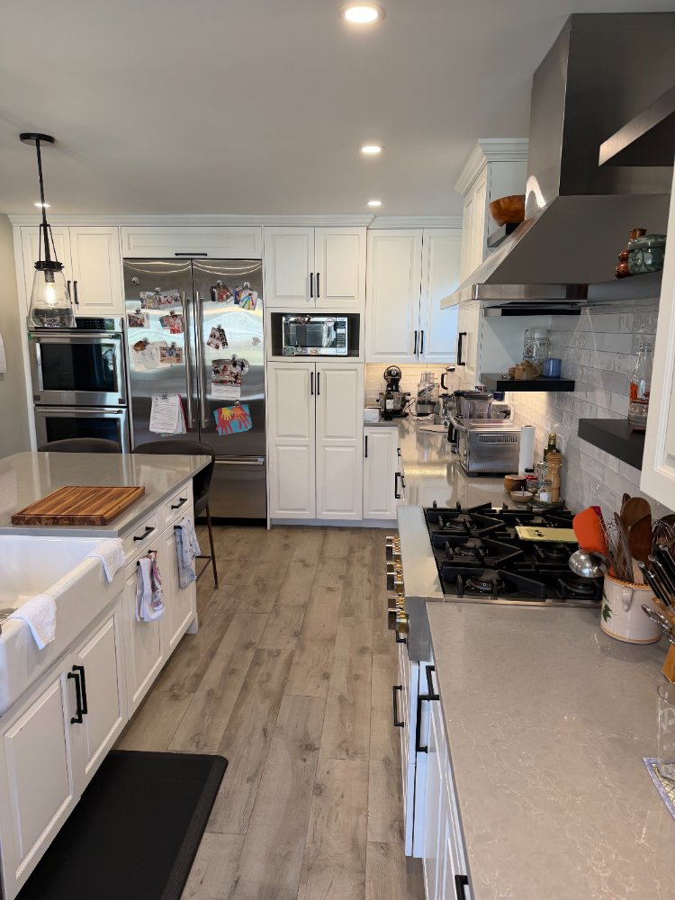 Modern kitchen renovation in Bethesda, MD showcasing white shaker cabinets, quartz countertops, and stainless steel appliances.