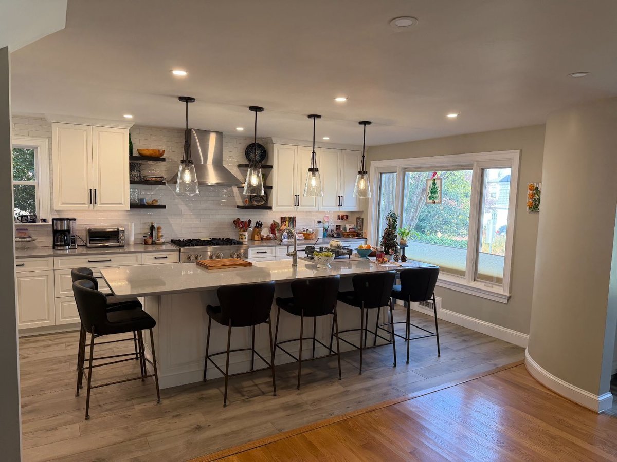 Spacious Bethesda, MD kitchen remodel with a quartz waterfall-style island, white cabinetry, and pendant lighting.