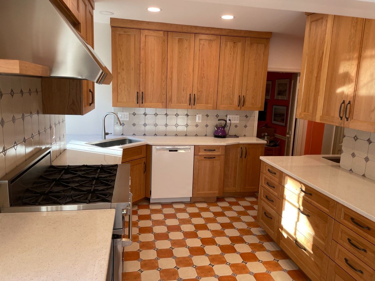 Elegant kitchen renovation featuring custom cabinetry, tile backsplash, and stainless steel appliances