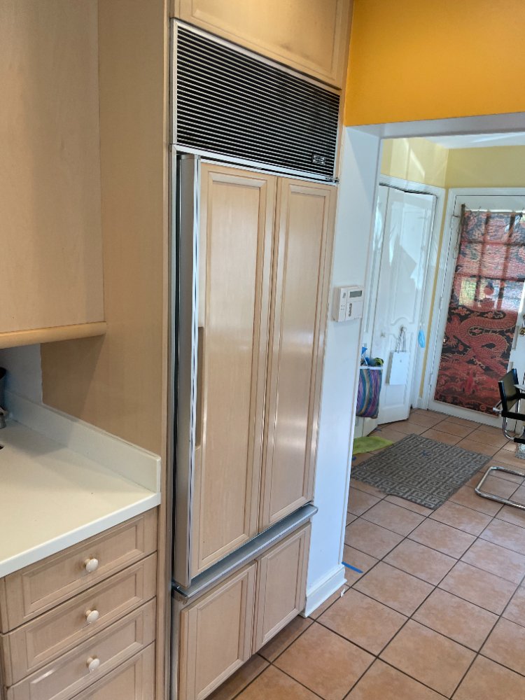 Existing integrated refrigerator and surrounding cabinetry before the kitchen remodel in Chevy Chase, MD.