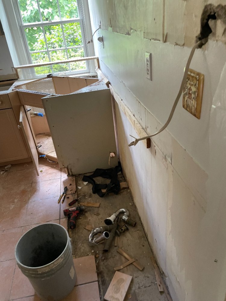 Demolition continues on the kitchen remodel in Chevy Chase, MD with exposed plumbing and wall prep.
