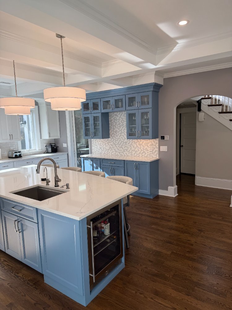 Bright Chevy Chase, MD remodeled kitchen with custom blue cabinets and quartz surfaces.