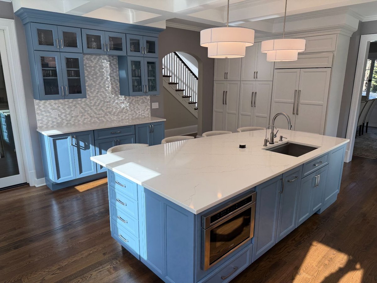 Remodeled kitchen featuring a blue quartz waterfall island, custom cabinetry, and a coffered ceiling in Chevy Chase, MD.